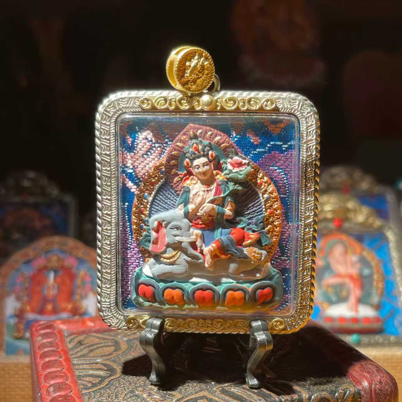 This is a Buddha amulet made of clay by artisans on the roof of the world, fired at high temperatures, and then hand-painted with mineral pigments. Its name is Samantabhadra Bodhisattva.