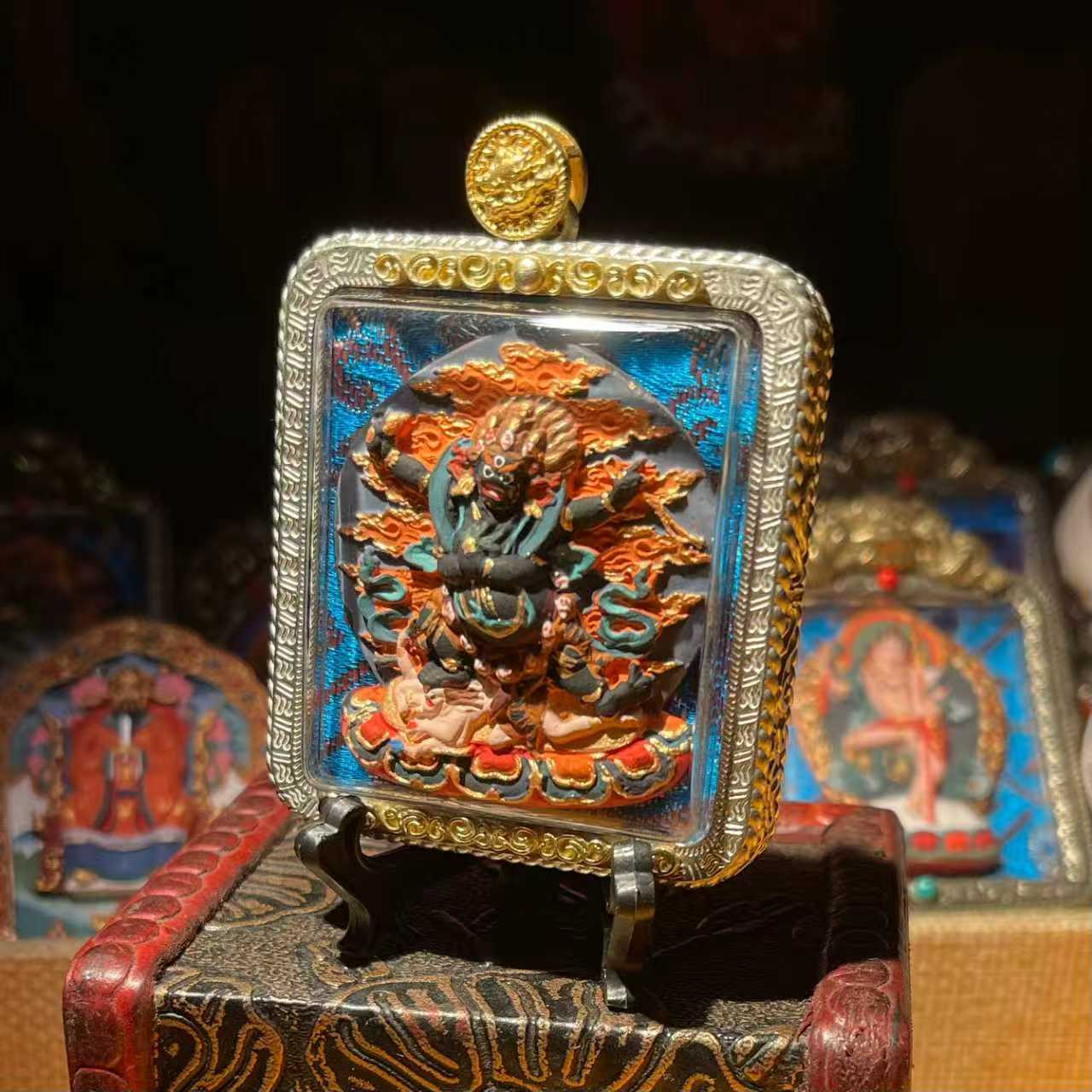 This is a Buddha amulet made of clay by artisans on the roof of the world. It was fired at high temperatures and then hand-painted with mineral pigments. Its name is the Four-Armed Vajra Conqueror.