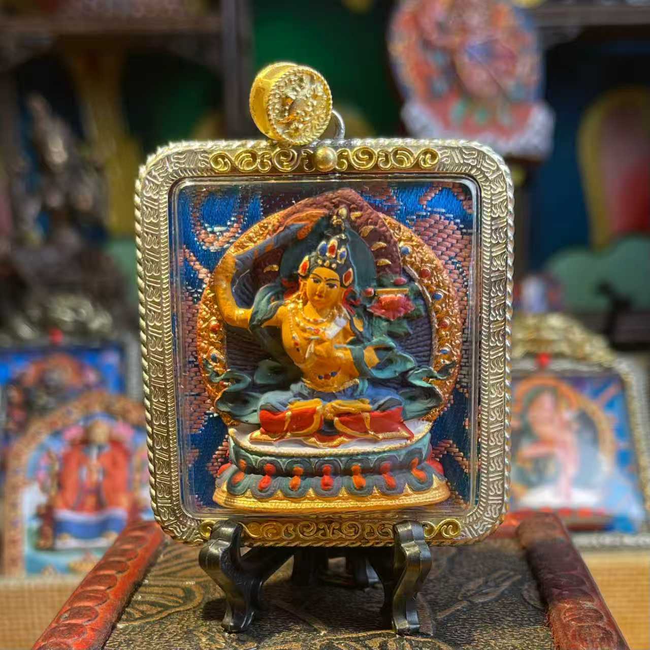 This is a Buddha amulet made of clay by artisans on the roof of the world, fired at high temperatures, and then hand-painted with mineral pigments. Its name is Manjushri Bodhisattva.