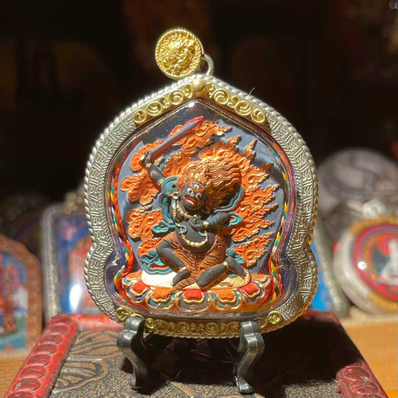 This is a Buddha amulet made of clay by artisans on the roof of the world, fired at high temperatures, and then hand-painted with mineral pigments. Its name is Acala (Fudō Myō-ō).