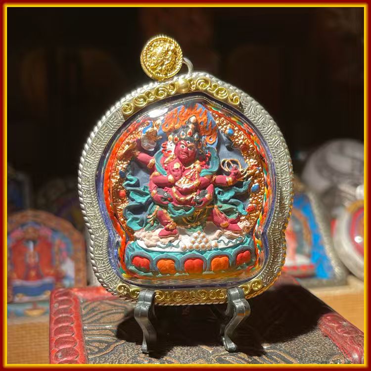 This is a Buddha amulet made of clay by artisans on the roof of the world, fired at high temperatures, and hand-painted with mineral pigments. Its name is Red Jambhala.