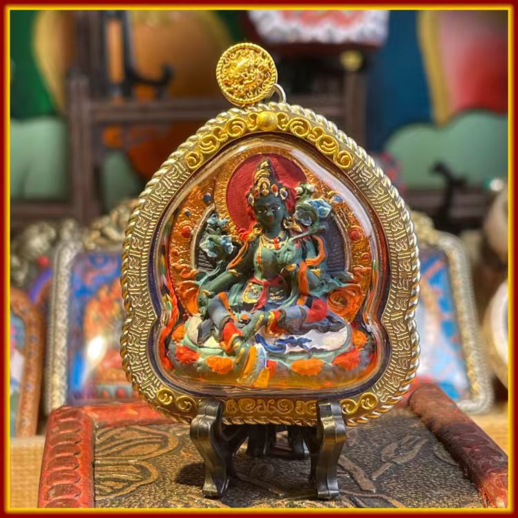 This is a Buddha amulet made of clay by artisans on the roof of the world, fired at high temperatures, and then hand-painted with mineral pigments. Its name is Green Tara.