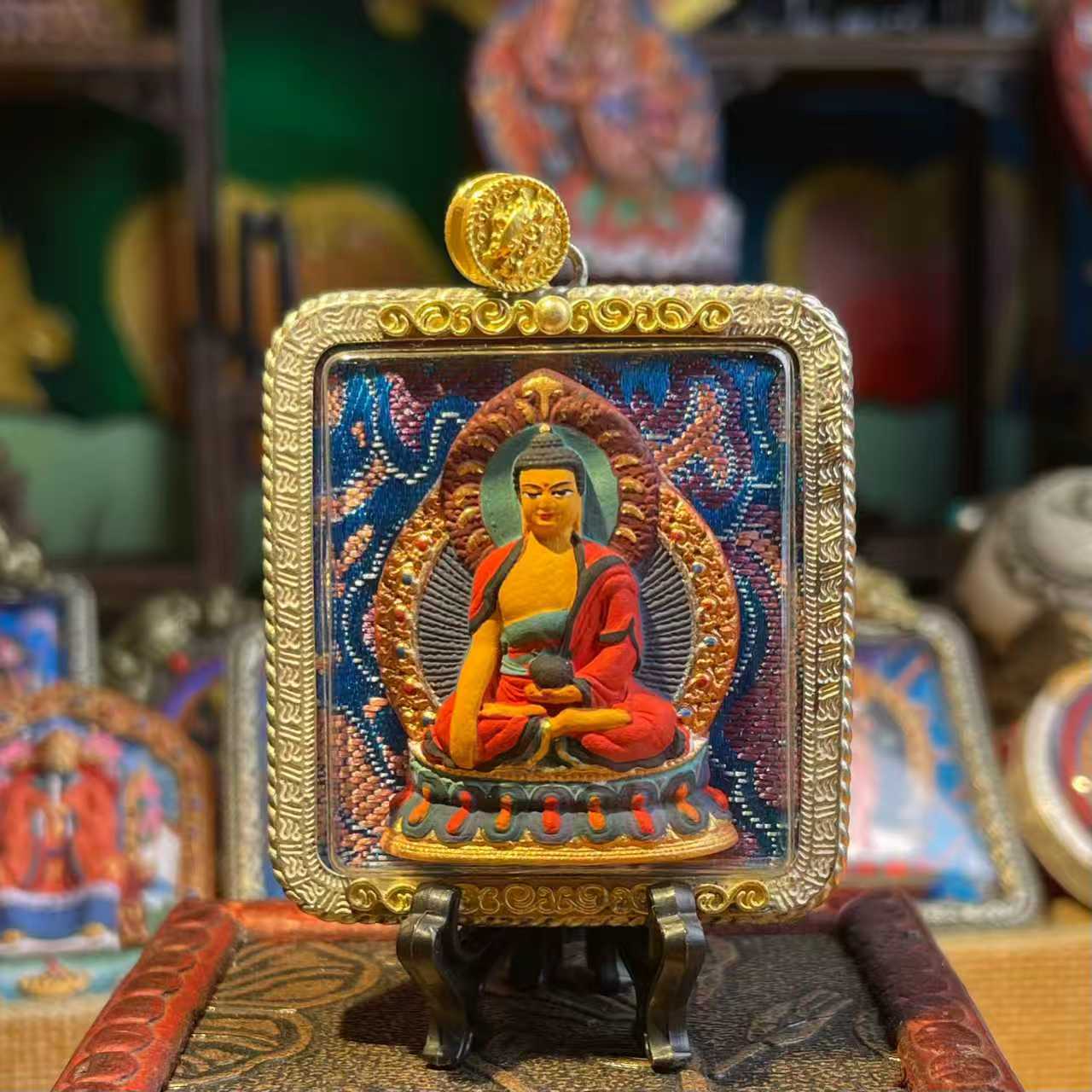 This is a Buddha amulet made of clay by artisans on the roof of the world, fired at high temperatures, and then hand-painted with mineral pigments. Its name is Shakyamuni Buddha.