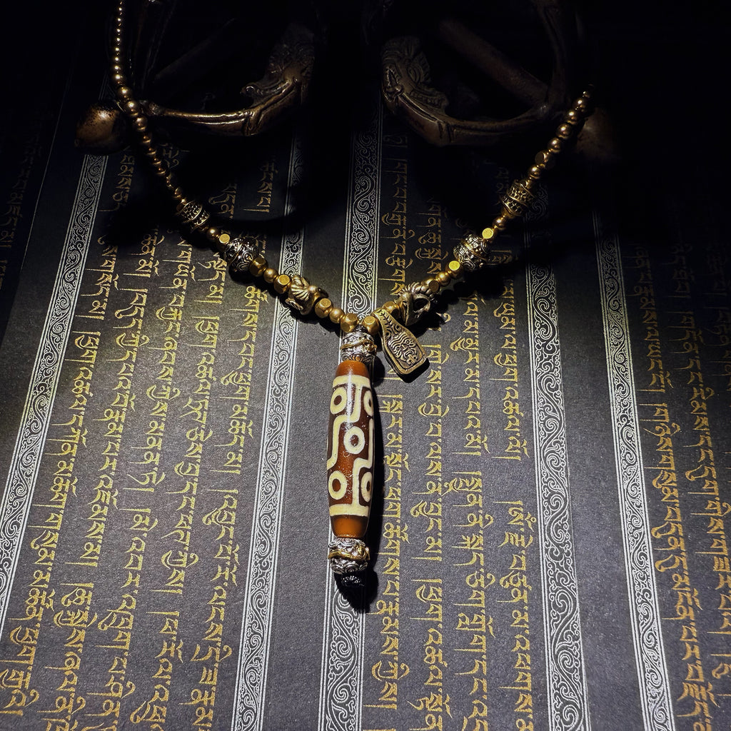 Tibetan Talisman — Handcrafted. Dzi bead necklaces and bracelets, prayer beads, thangkas, and ritual objects.This Dzi bead talisman necklace is an exceptionally beautiful, entirely handcrafted piece by Tibetan artisans, believed to hold powerful energy.