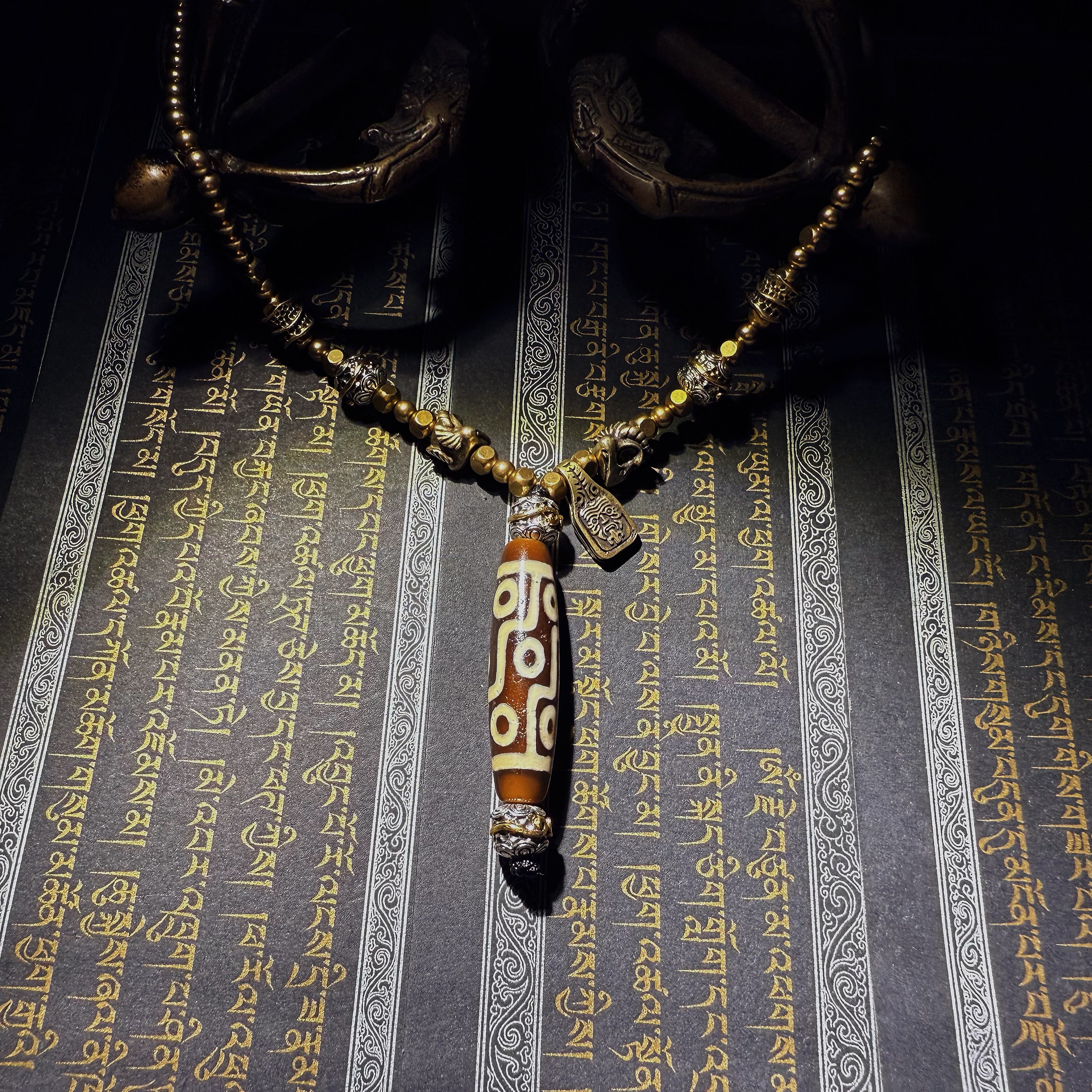 Tibetan Talisman — Handcrafted. Dzi bead necklaces and bracelets, prayer beads, thangkas, and ritual objects.This Dzi bead talisman necklace is an exceptionally beautiful, entirely handcrafted piece by Tibetan artisans, believed to hold powerful energy.