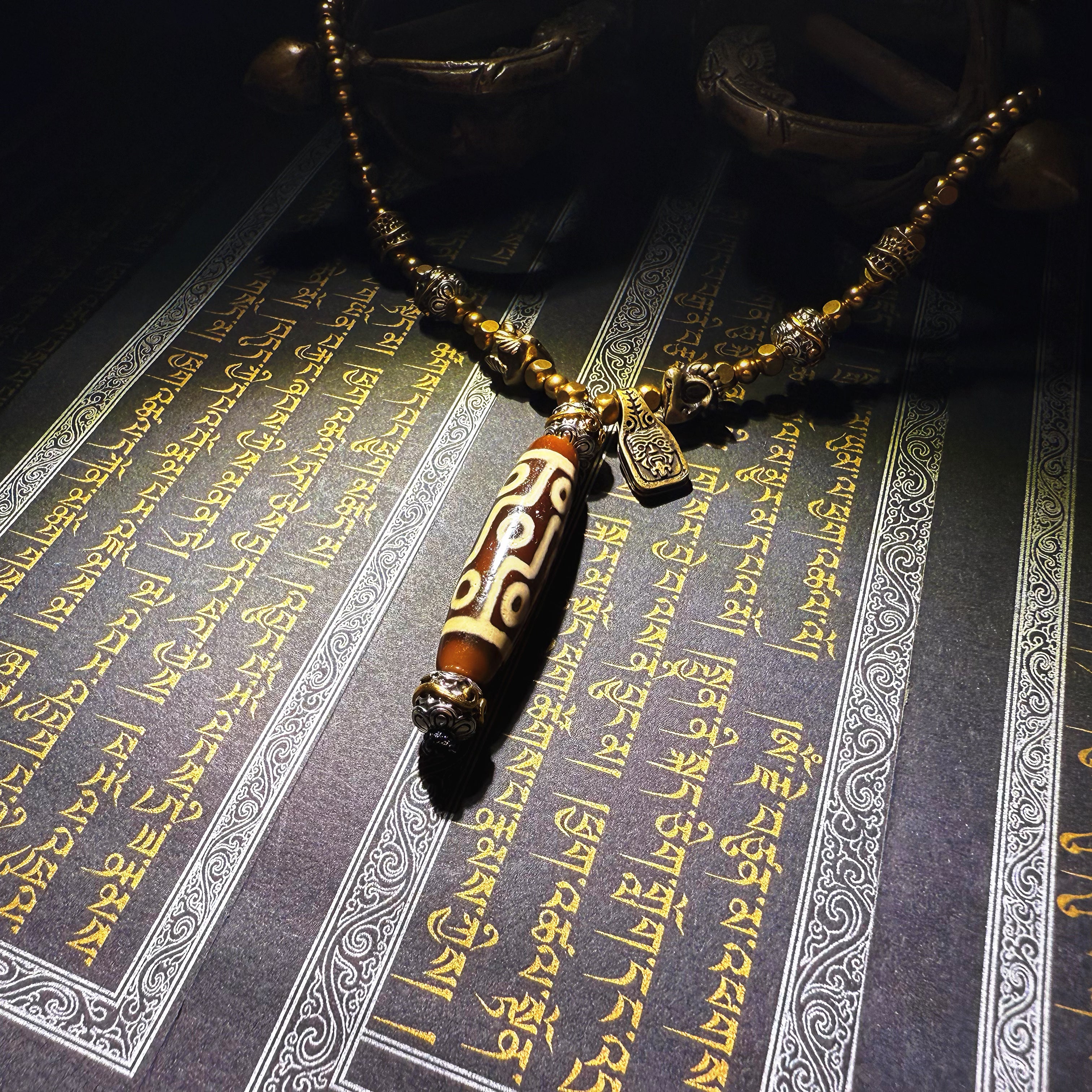 Tibetan Talisman — Handcrafted. Dzi bead necklaces and bracelets, prayer beads, thangkas, and ritual objects.This Dzi bead talisman necklace is an exceptionally beautiful, entirely handcrafted piece by Tibetan artisans, believed to hold powerful energy.