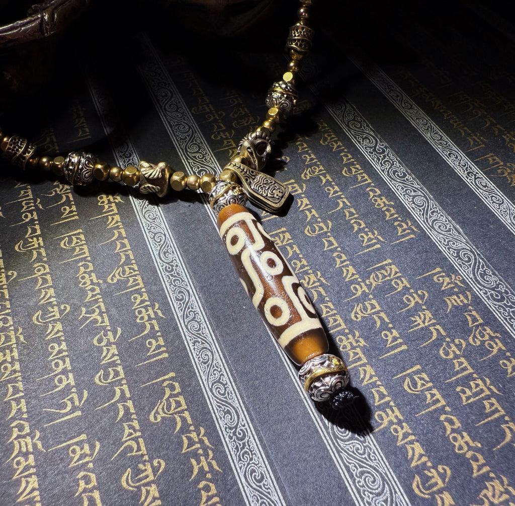 Tibetan Talisman — Handcrafted. Dzi bead necklaces and bracelets, prayer beads, thangkas, and ritual objects.This Dzi bead talisman necklace is an exceptionally beautiful, entirely handcrafted piece by Tibetan artisans, believed to hold powerful energy.