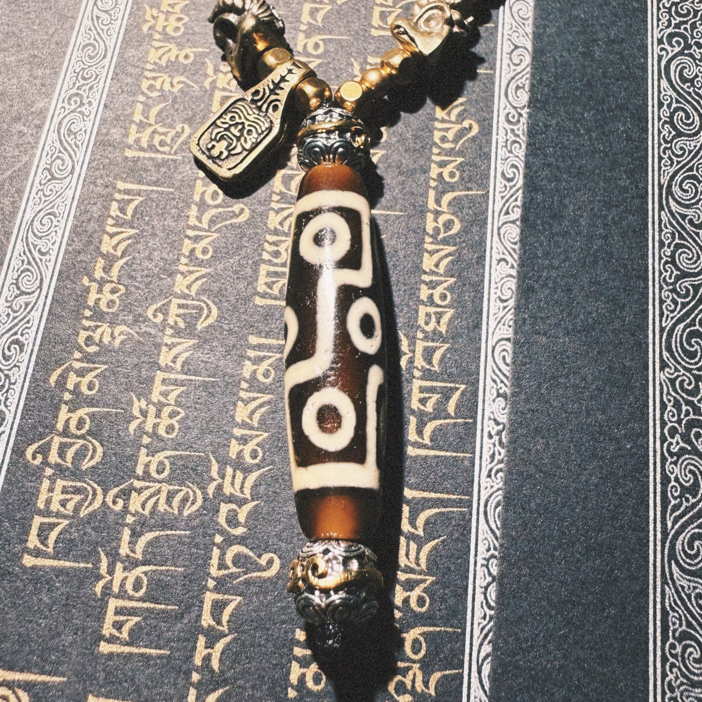 Tibetan Talisman — Handcrafted. Dzi bead necklaces and bracelets, prayer beads, thangkas, and ritual objects.This Dzi bead talisman necklace is an exceptionally beautiful, entirely handcrafted piece by Tibetan artisans, believed to hold powerful energy.