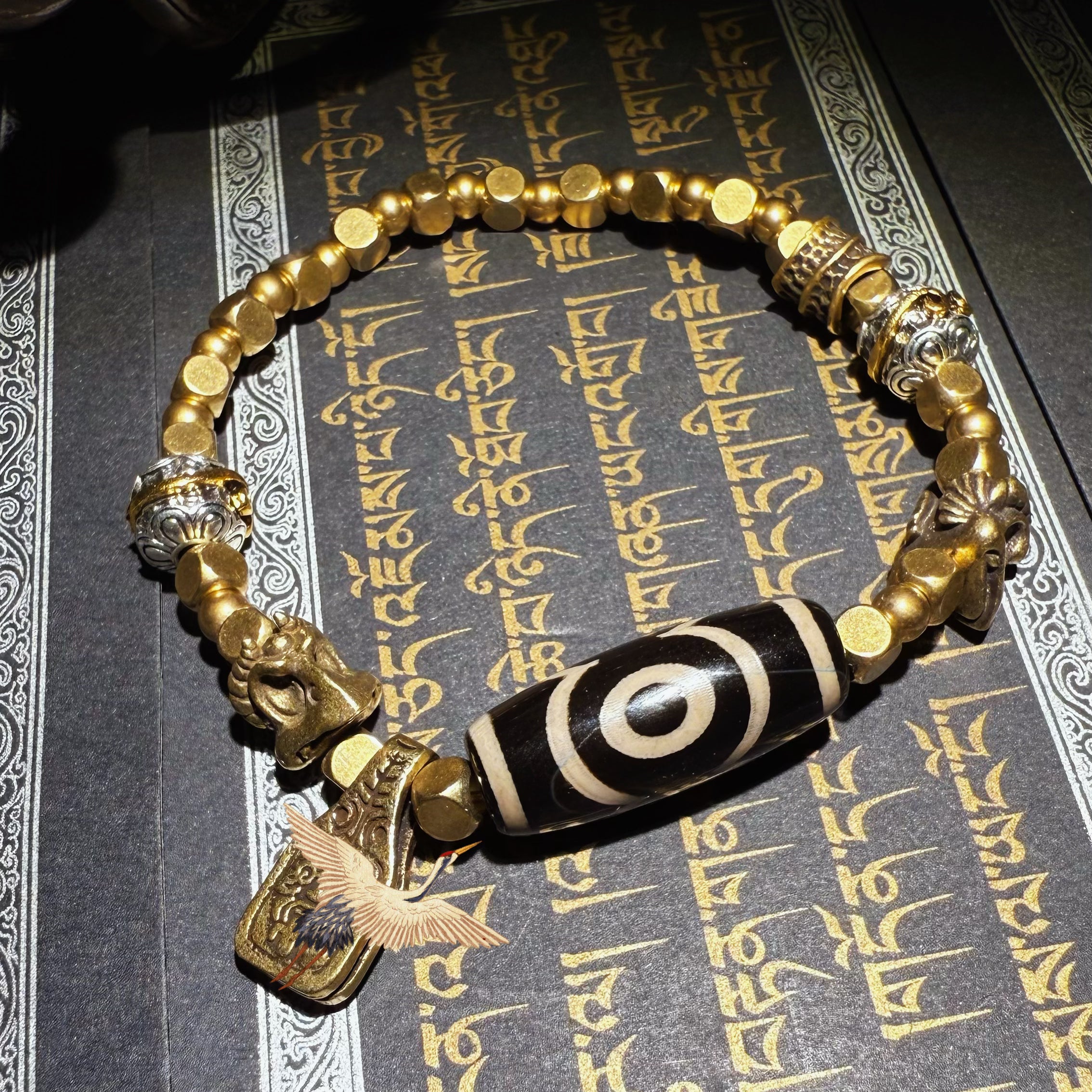 Tibetan amulets – handmade. Includes dzi bead necklaces, bracelets, prayer beads, thangkas, and ritual implements. This dzi bead amulet bracelet is exquisitely handcrafted by Tibetan artisans and is believed to contain powerful energy.