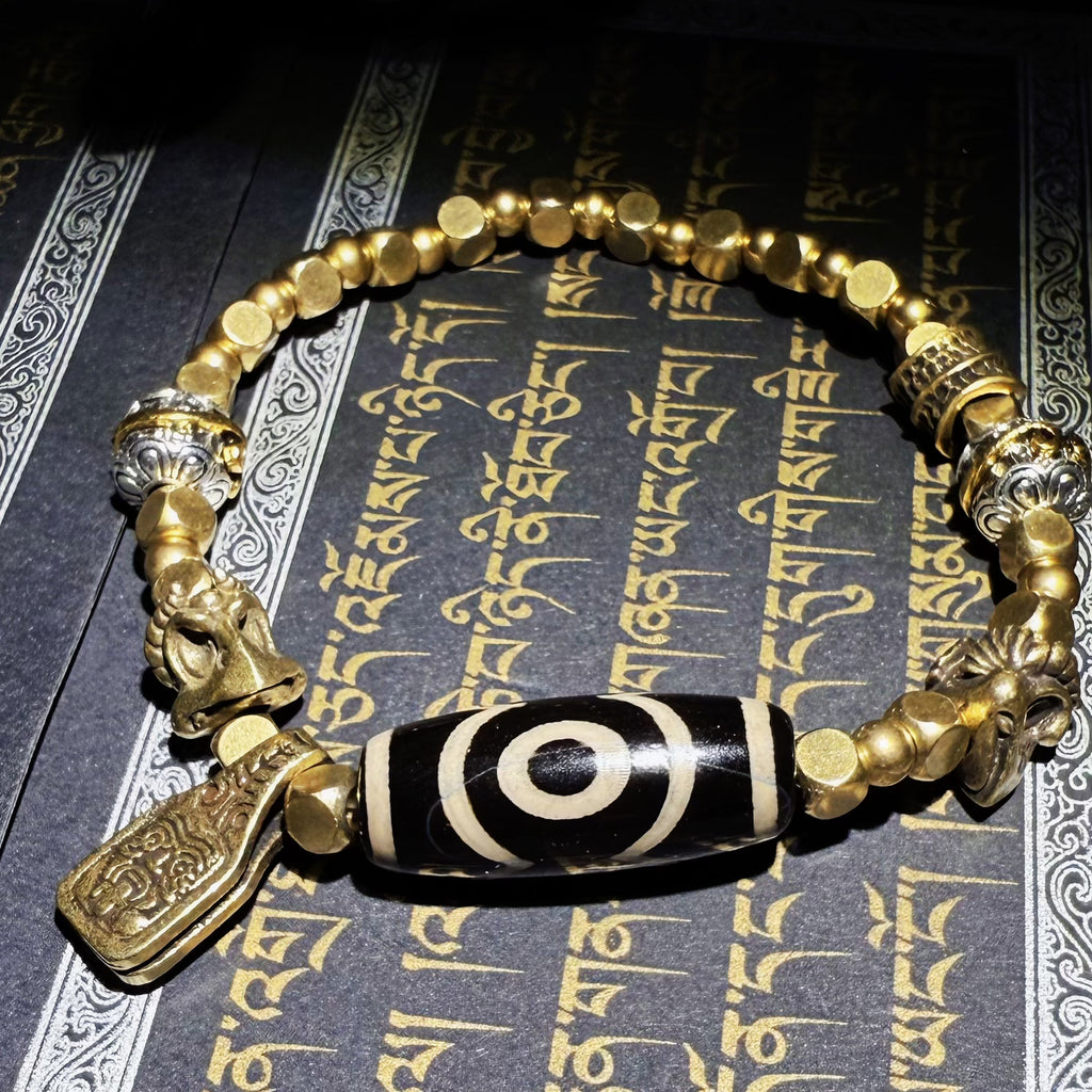 Tibetan amulets – handmade. Includes dzi bead necklaces, bracelets, prayer beads, thangkas, and ritual implements. This dzi bead amulet bracelet is exquisitely handcrafted by Tibetan artisans and is believed to contain powerful energy.