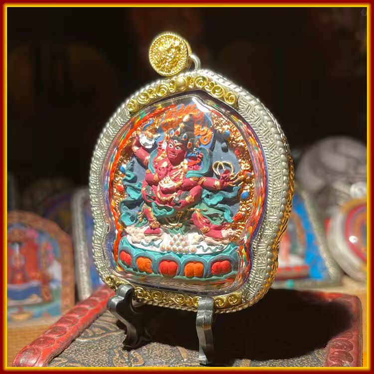 This is a Buddha amulet made of clay by artisans on the roof of the world, fired at high temperatures, and hand-painted with mineral pigments. Its name is Red Jambhala.