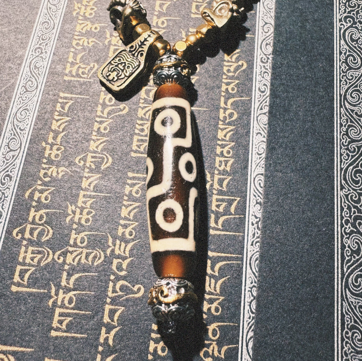 Tibetan Talisman — Handcrafted. Dzi bead necklaces and bracelets, prayer beads, thangkas, and ritual objects.This Dzi bead talisman necklace is an exceptionally beautiful, entirely handcrafted piece by Tibetan artisans, believed to hold powerful energy.