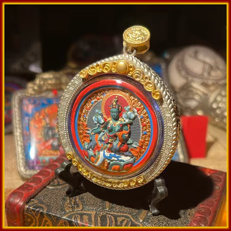 These are amulets made of clay by artisans on the roof of the world, fired at high temperatures and then hand-painted with mineral pigments. Its name is Green Tara.