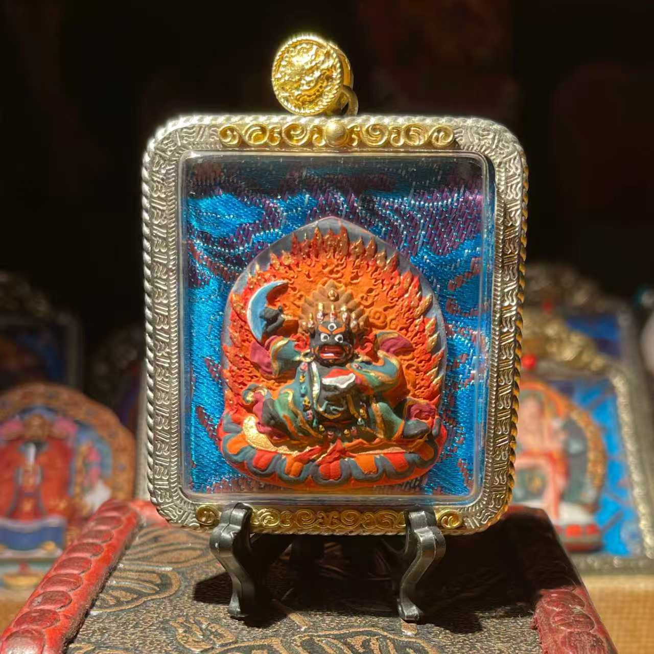 This is a Buddhist amulet made of clay by artisans on the roof of the world, fired at high temperatures, and then hand-painted with mineral pigments. Its name is Black Robe Vajra.