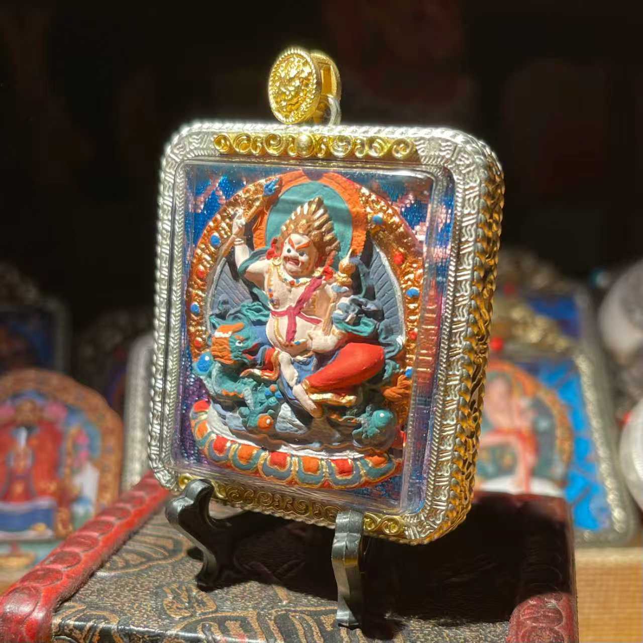 This is a Buddha amulet made of clay by artisans on the roof of the world, fired at high temperatures, and then hand-painted with mineral pigments. Its name is White Jambhala.