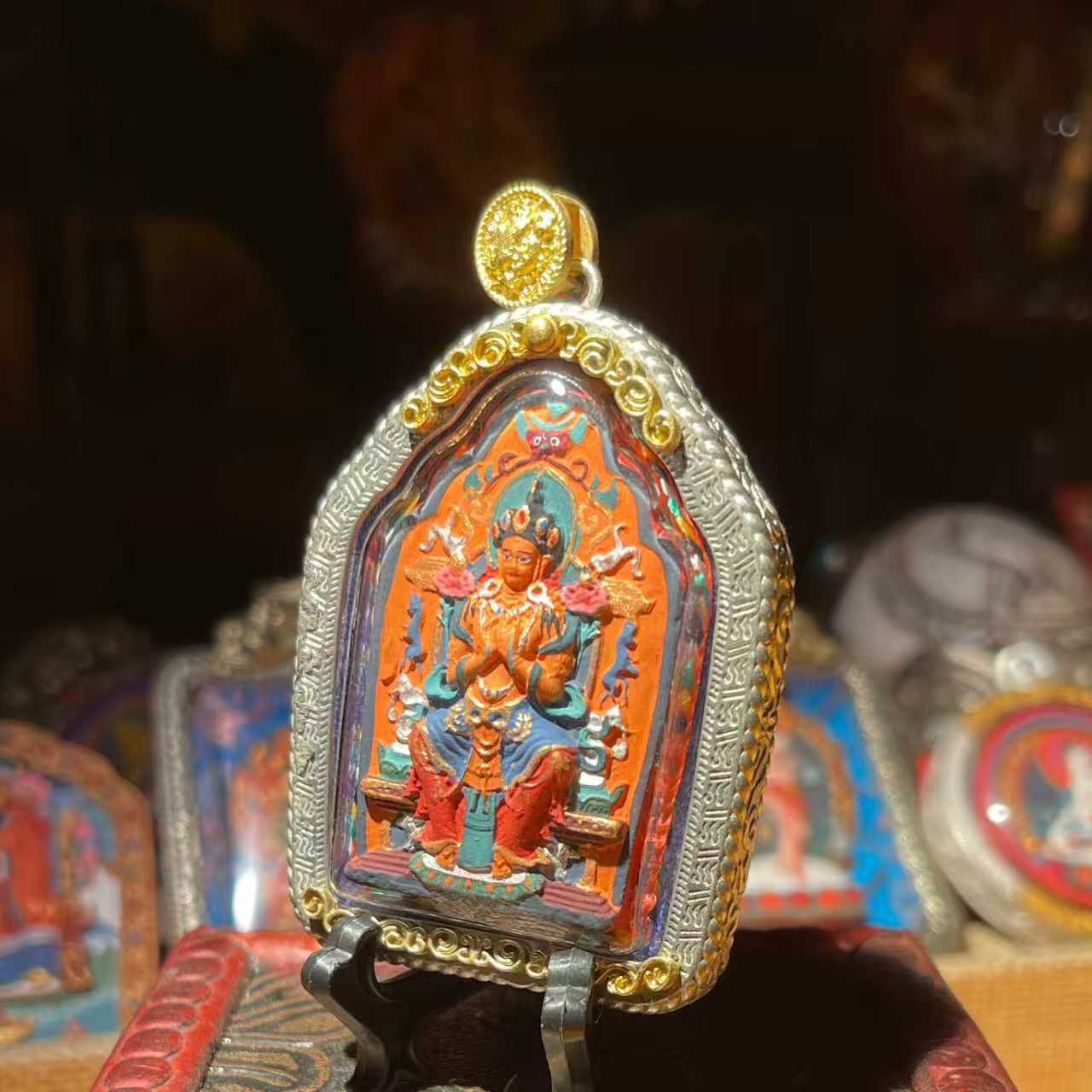 This is a Buddha amulet made of clay by artisans on the roof of the world, fired at high temperatures, and then hand-painted with mineral pigments. Its name is Maitreya Buddha.