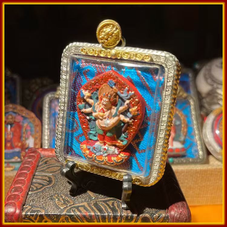 This is a Buddha amulet made of clay by artisans on the roof of the world. It was fired at high temperatures and then hand-painted with mineral pigments. Its name is White Six-Armed Mahakala.