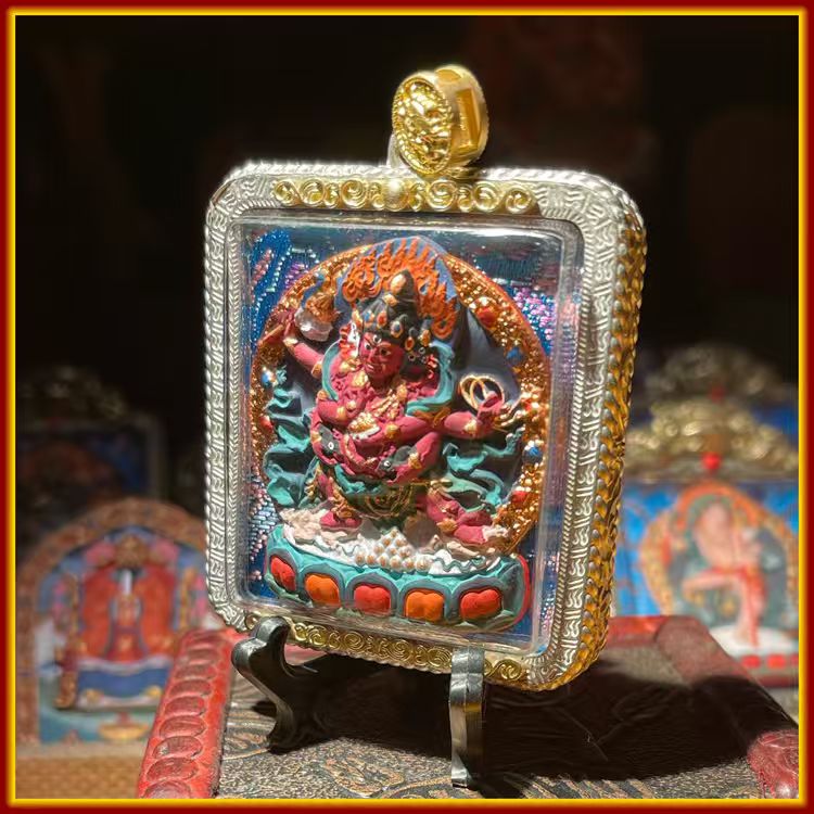 This is a Buddha amulet handcrafted from clay by artisans on the roof of the world. It was fired at high temperatures and then hand-painted with mineral pigments. Its name is "Red Jambhala".