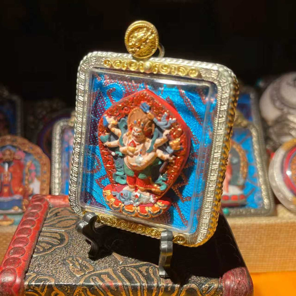 This is a Buddha amulet made of clay by artisans on the roof of the world. It was fired at high temperatures and then hand-painted with mineral pigments. Its name is White Six-Armed Mahakala.