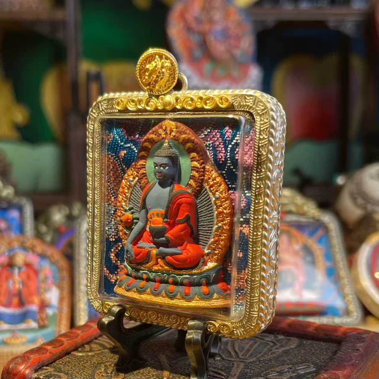 This is a Buddha amulet made of clay by artisans on the roof of the world, fired at high temperatures, and then hand-painted with mineral pigments. Its name is Medicine Buddha.
