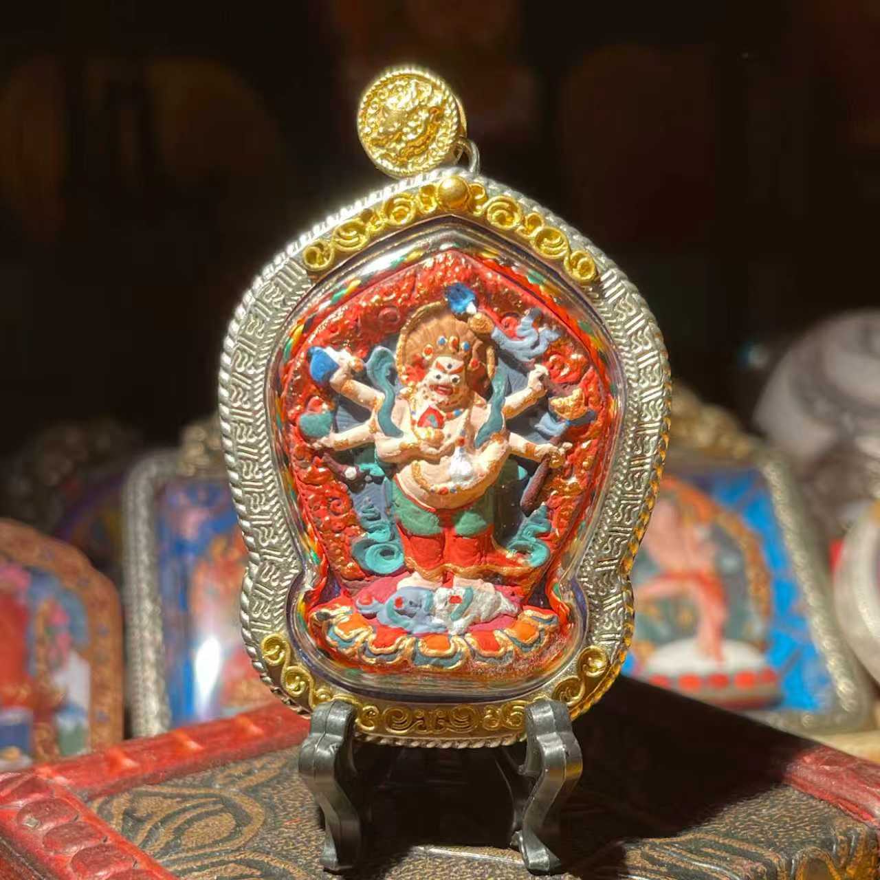 This is a Buddha amulet made of clay by artisans on the roof of the world, fired at high temperatures, and then hand-painted with mineral pigments. Its name is White Six-Bi Mahakala.