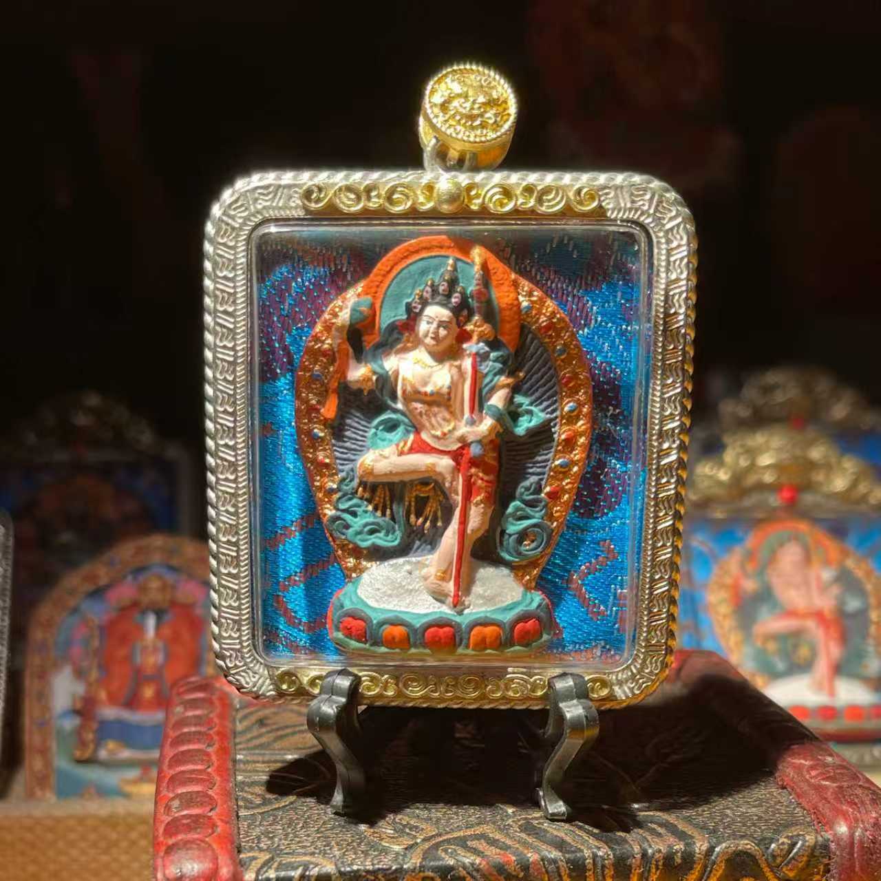 This is a Buddha amulet made of clay by artisans on the roof of the world, fired at high temperatures, and then hand-painted with mineral pigments. Its name is Machig Labdron.